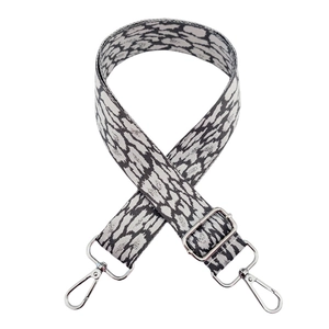 Close-up of leopard print bag strap with silver metal lobster clasps and buckle