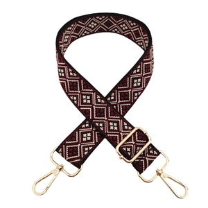 Close-up of ethnic jacquard wide shoulder strap with geometric patterns and gold clips