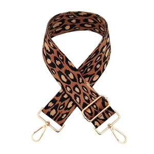 Détail de la bandoulière réglable en nylon léopard avec mousqueton doré brillant