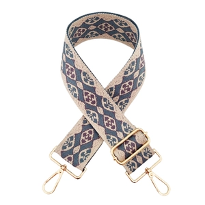 Detail eines bunten Jacquard-Taschenriemens mit Rautenmuster und goldenen Karabinern