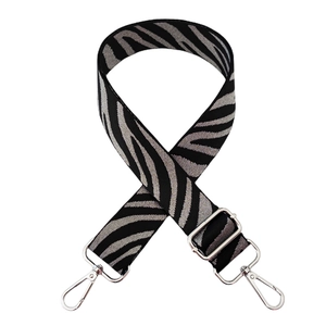 Detail of adjustable zebra print bag strap with polished silver metal lobster claws