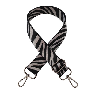 Detail of zebra pattern shoulder strap with black metal hooks and woven texture