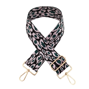 Détail d'une bandoulière léopard jacquard rose et vert avec fermoir mousqueton en métal doré