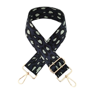 Détail de la bandoulière réglable en nylon léopard avec mousquetons dorés métalliques