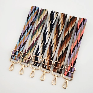 Detail of six adjustable woven bag straps with geometric patterns and gold metal buckles