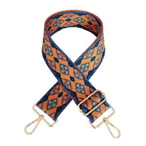 Detail eines gewebten Ethno-Taschengaruts mit orange-blauen Mustern und Goldclips