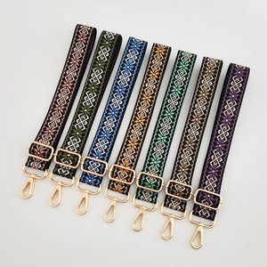 Detail view of woven guitar style bag straps with colorful ethnic patterns and gold buckles