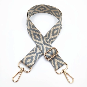 Detail of adjustable bag strap with grey diamond embroidery and gold metal lobster clasps