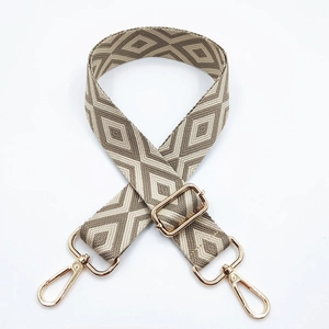 Detailed view of coffee and beige geometric diamond embroidery strap with gold hooks