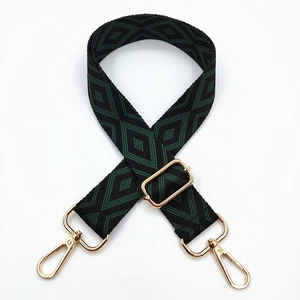 Close-up of adjustable embroidered geometric diamond strap with gold metal buckles