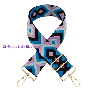 Detail of adjustable embroidered bag strap with purple diamond patterns and gold hooks