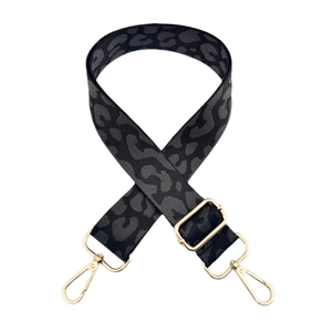 Detail view of adjustable leopard print nylon bag strap with gold metal buckles