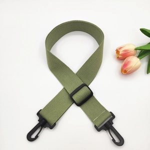 Close-up of grass green woven shoulder strap with black plastic swivel hooks and slider