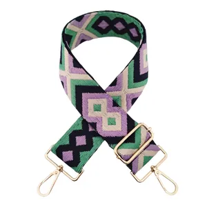 Close-up of bohemian geometric woven shoulder strap with gold swivel hooks and buckle