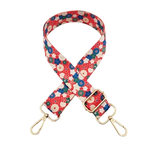 Détail de la bandoulière fleurie avec des mousquetons en métal doré poli