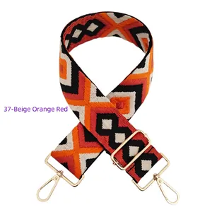 Detail of 5cm wide adjustable woven bag strap with geometric embroidery and gold hardware