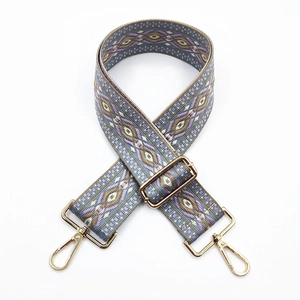 Close-up of ethnic jacquard purse strap with gold hardware and colorful geometric weave