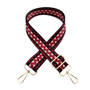 Detail of red and black zigzag pattern guitar strap for handbags with gold metal hooks