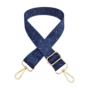Detailed macro view of dark blue star and moon pattern strap with gold metal hardware