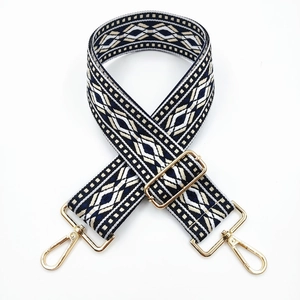 Detail of blue and white ethnic geometric pattern bag strap with gold metal hooks