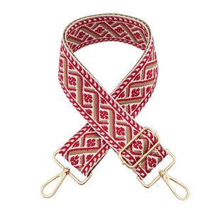 Close-up of red and gold geometric ethnic style wide woven strap with metal lobster clasps