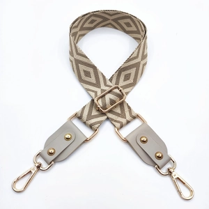 Détail d'une bandoulière jacquard géométrique réglable avec embouts cuir et boucles dorées