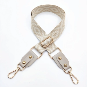 Détail macro de la bandoulière jacquard avec cuir gris et boucles dorées chic