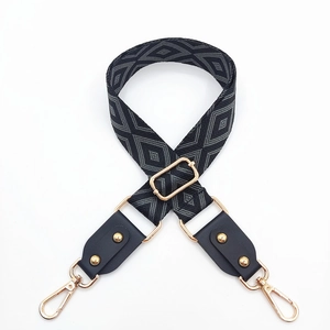 Détail de la bandoulière réglable à motifs géométriques avec rivets dorés et clips
