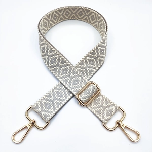 Adjustable geometric embroidery bag strap with gold metal hooks on white background