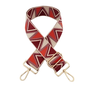 Close-up of colorful geometric jacquard wide bag strap with golden metal lobster clasps