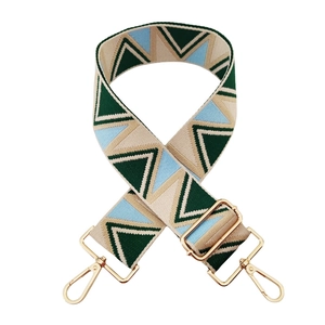 Macro view of adjustable bohemian geometric pattern wide strap with gold metal hooks