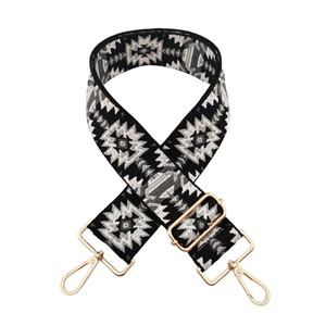 Close-up of ethnic geometric jacquard bag strap with adjustable light gold metal hardware