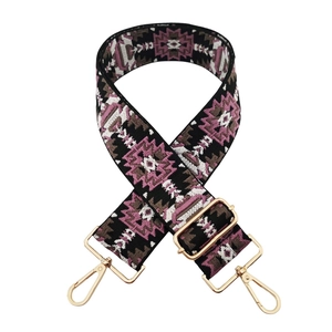 Close-up of ethnic geometric pattern strap with gold-tone hardware and adjustable buckle