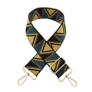 Detail of geometric jacquard bag strap with vintage sawtooth pattern and gold lobster clasps