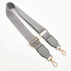 Adjustable grey shoulder strap for handbags featuring golden hooks and meander pattern