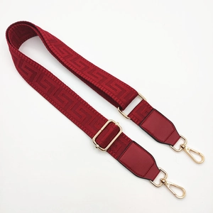 Burgundy woven adjustable bag strap with gold metal hardware and geometric pattern