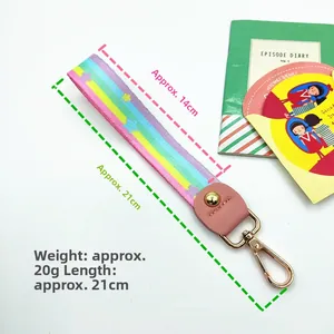 Detailed view of rainbow strap with pink leather connector and gold metal spring clasp