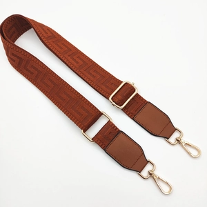 Adjustable brown geometric pattern crossbody bag strap with gold metal buckles