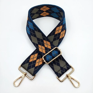 Macro detail of navy and orange argyle woven shoulder strap with gold swivel lobster clasps