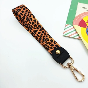 Macro detail of classic leopard print fabric wrist strap with gold metal lobster clasp
