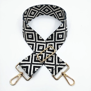 Detail of black and white geometric woven bag strap with durable golden metal lobster clasps
