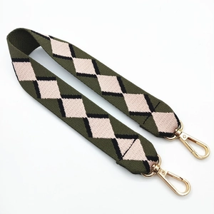 Detail of bohemian jacquard woven strap with green rhombus pattern and gold metal hooks