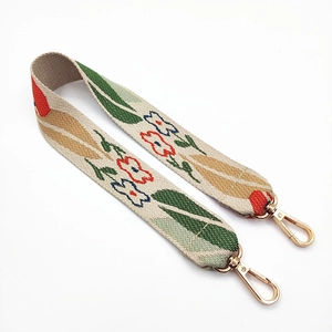 Close-up of ethnic style embroidered floral bag strap with golden metal swivel hooks