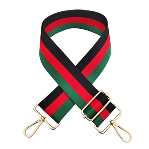 Detail of red and green striped shoulder strap with adjustable golden metal hardware