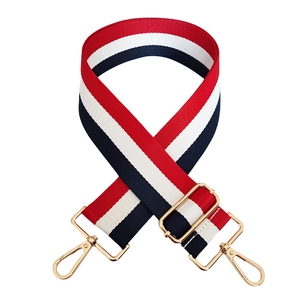 Detail of red white and navy striped canvas strap with adjustable golden metal buckles