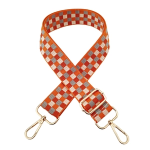 Close-up of adjustable orange and grey checkered nylon bag strap with gold metal hooks