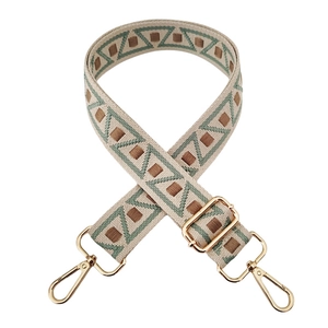 Detail of high-density geometric woven strap with gold metal lobster clasps and slider