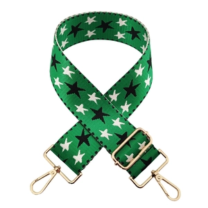 Detail of adjustable green woven strap with black and white star pattern and gold buckles