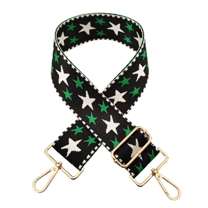 Detail of adjustable nylon bag strap featuring embroidered green and white stars
