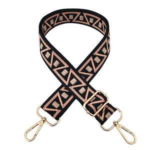 Close-up of geometric woven bag strap with ethnic patterns and gold metal hardware